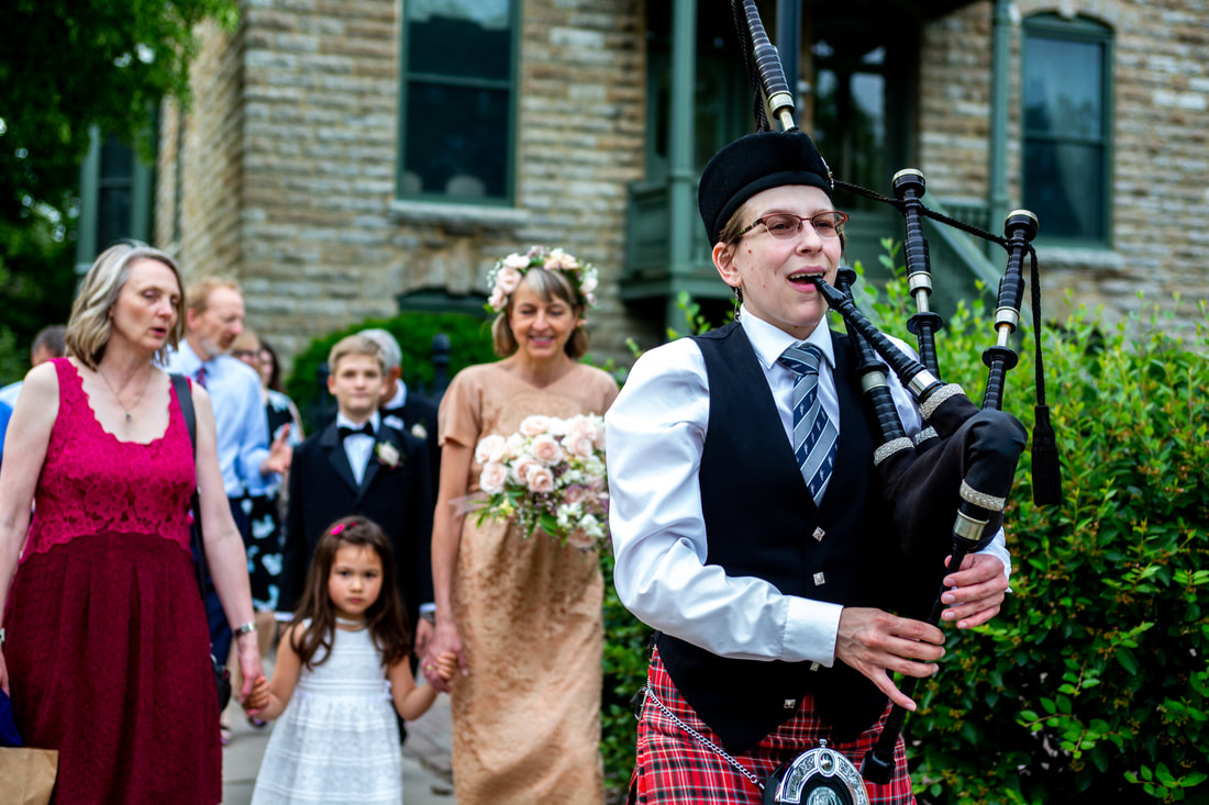 Bagpipes lead a parade of wedding guests to the wedding reception venue, Minneapolis, MN