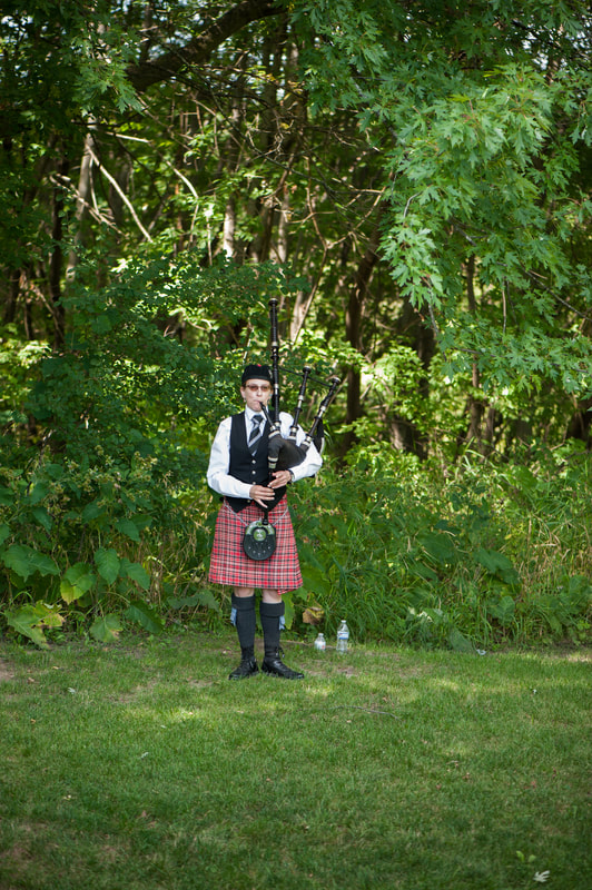 Meridith playing her bagpipes as guests arrive for wedding ceremony, Bloom Lake Barn, Shafer, MN